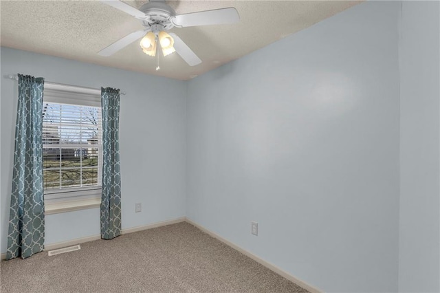 spare room featuring visible vents, baseboards, ceiling fan, carpet, and a textured ceiling