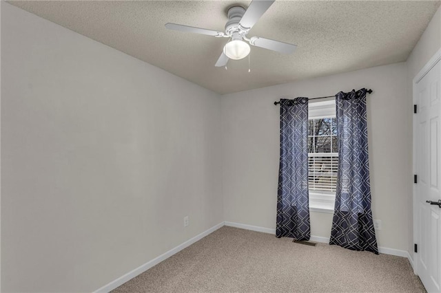 unfurnished room featuring baseboards, light carpet, a textured ceiling, and a ceiling fan