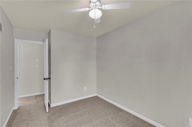 spare room featuring carpet flooring, ceiling fan, a textured ceiling, and baseboards