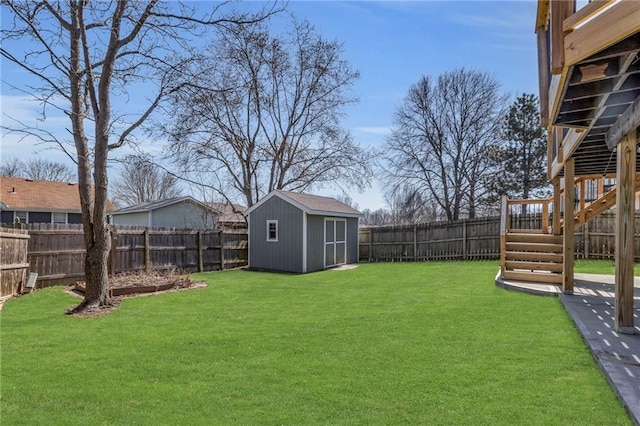 view of yard featuring stairs, an outbuilding, a storage unit, and a fenced backyard