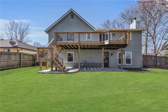 rear view of house featuring a lawn, a fenced backyard, stairway, a wooden deck, and a chimney