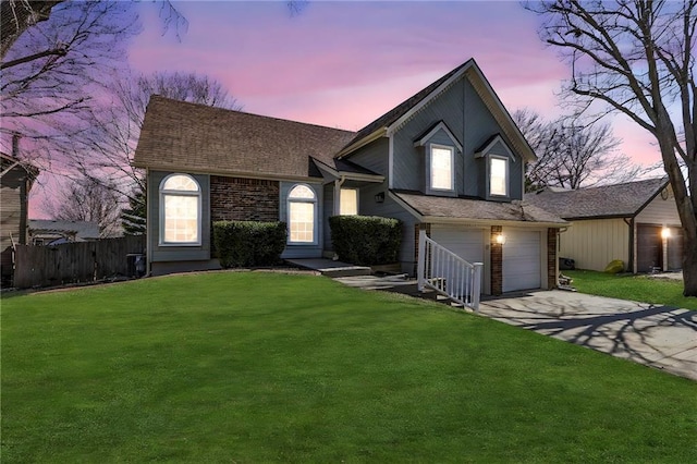 view of front of property featuring a front lawn, fence, concrete driveway, roof with shingles, and an attached garage