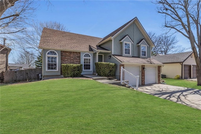 tri-level home with fence, roof with shingles, an attached garage, a front lawn, and concrete driveway