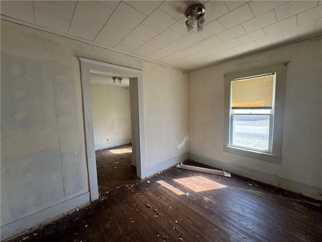 empty room featuring baseboards and hardwood / wood-style flooring