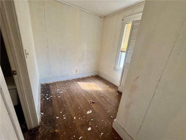 unfurnished room featuring wood-type flooring and baseboards