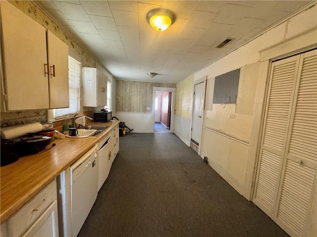 kitchen featuring visible vents, white dishwasher, light countertops, black microwave, and a sink