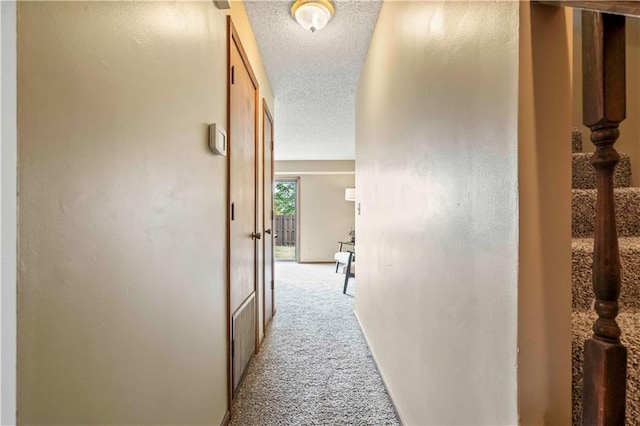 hall with light carpet and a textured ceiling