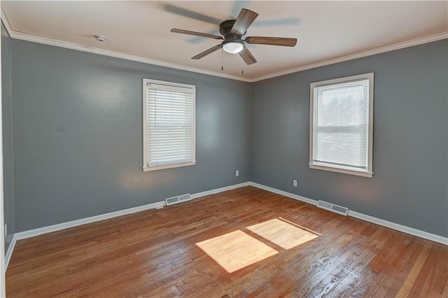 unfurnished room with ornamental molding, wood finished floors, and visible vents