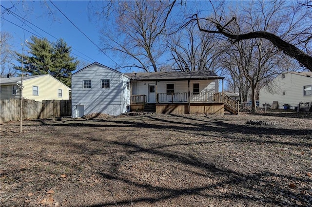 rear view of house featuring a deck and fence