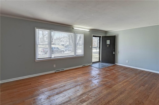 entryway featuring ornamental molding, visible vents, baseboards, and wood finished floors