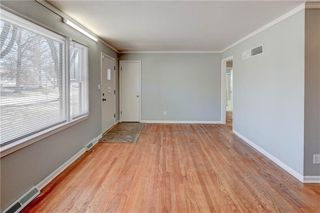 interior space with ornamental molding, visible vents, and baseboards