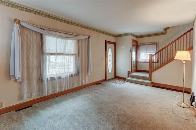 carpeted entrance foyer with visible vents, baseboards, and stairs