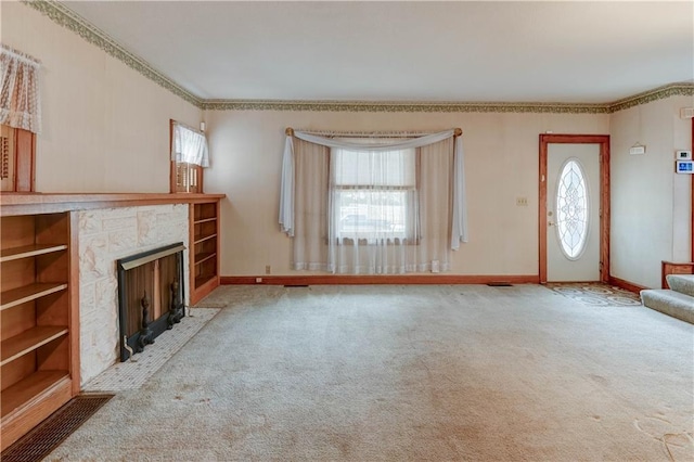 unfurnished living room featuring carpet, baseboards, ornamental molding, and a fireplace with flush hearth