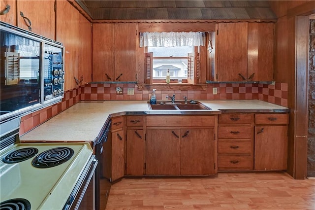 kitchen featuring light wood-type flooring, electric stove, light countertops, and a sink