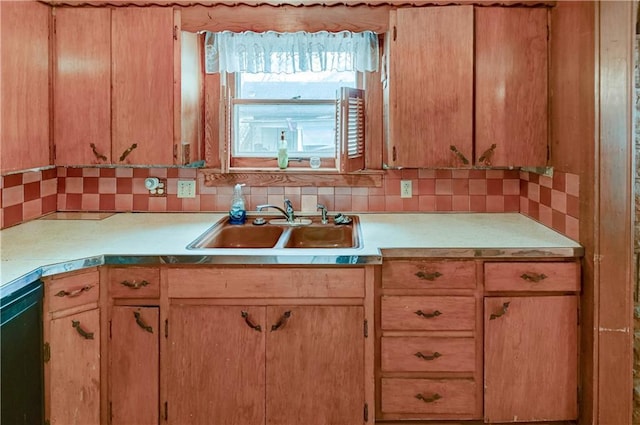 kitchen featuring tasteful backsplash, black dishwasher, light countertops, and a sink