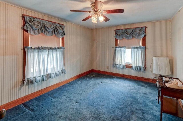 spare room with ceiling fan, carpet, and baseboards