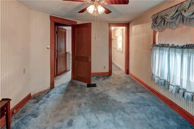 unfurnished room with carpet flooring, ceiling fan, baseboards, and wallpapered walls