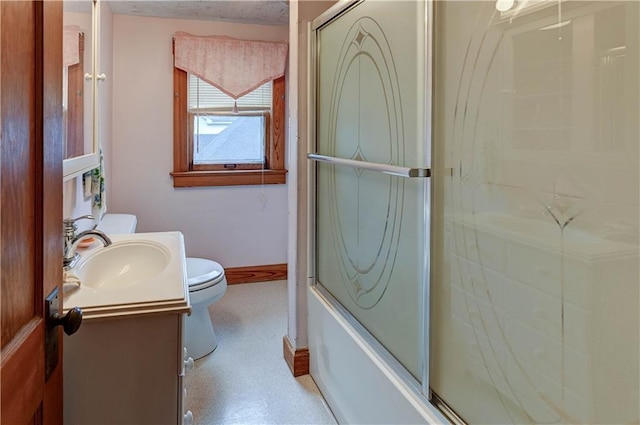 full bathroom with baseboards, vanity, and toilet