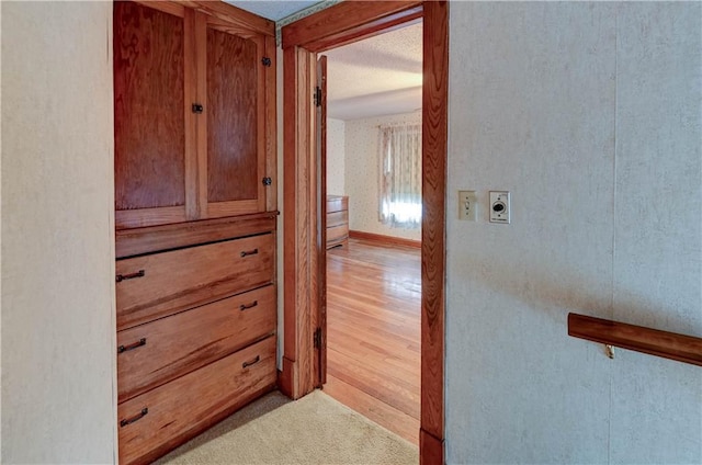 hall featuring baseboards and light wood finished floors