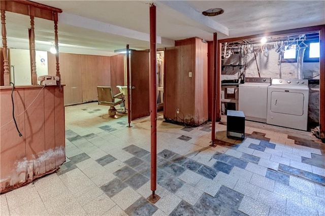 below grade area with wooden walls, separate washer and dryer, and tile patterned floors