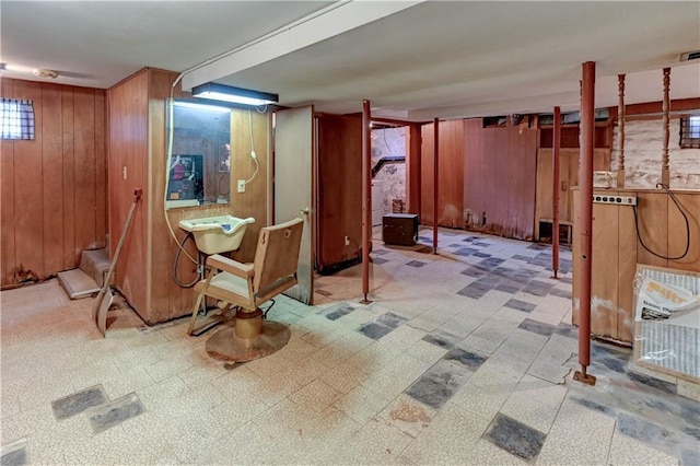 finished basement featuring wood walls and tile patterned floors