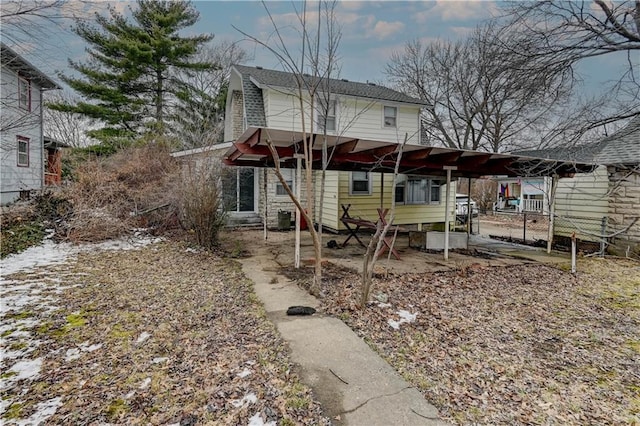 back of property featuring roof with shingles