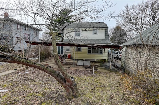 back of house featuring roof with shingles