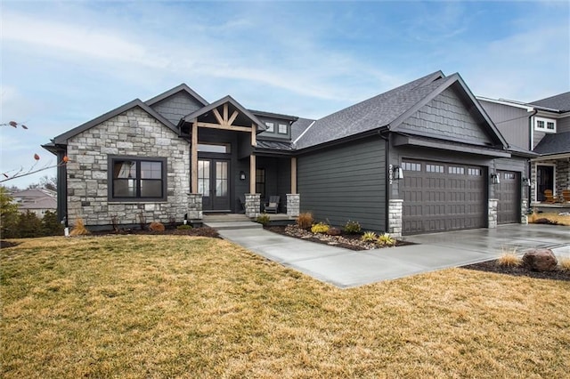 craftsman-style house featuring a front yard, stone siding, driveway, and an attached garage