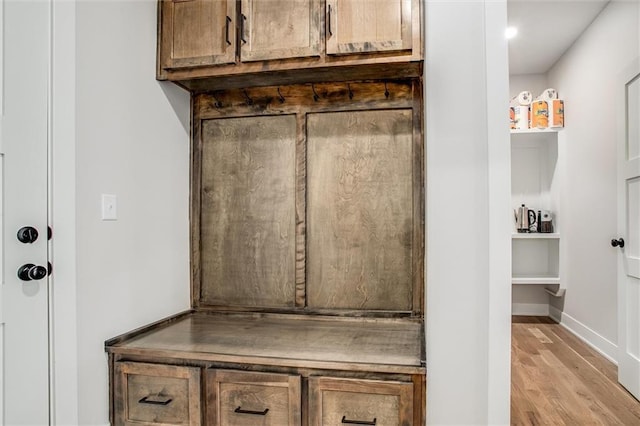 mudroom with light wood finished floors and baseboards