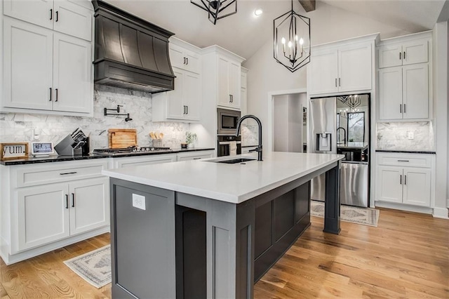 kitchen featuring custom exhaust hood, light wood-style floors, tasteful backsplash, lofted ceiling with beams, and stainless steel appliances