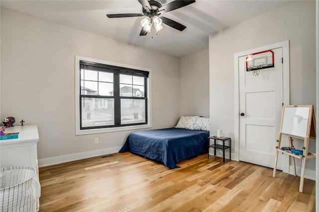 bedroom with light wood-type flooring, a ceiling fan, baseboards, and visible vents