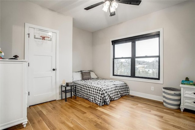 bedroom featuring baseboards, ceiling fan, and light wood finished floors