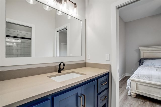 bathroom featuring baseboards, wood finished floors, and vanity
