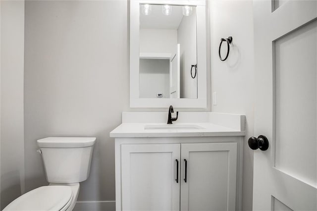 half bathroom featuring vanity and toilet