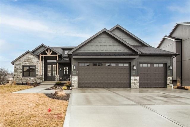 craftsman inspired home with a garage, stone siding, and driveway