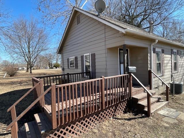 view of front facade with central AC and a wooden deck