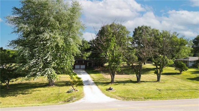 surrounding community with a garage, a lawn, and driveway