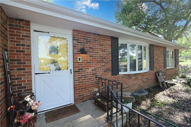 doorway to property with brick siding