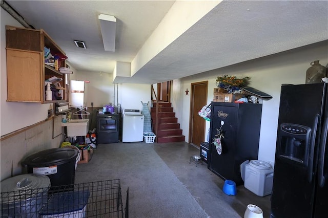 interior space with a sink, washer / dryer, stairs, and black fridge