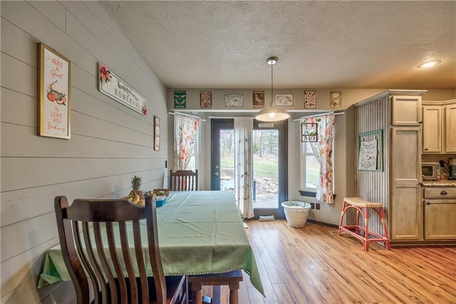 dining area featuring light wood-style flooring and a textured ceiling