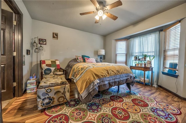 bedroom featuring a textured ceiling, ceiling fan, and wood finished floors