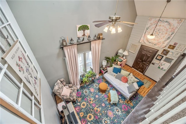 living room featuring a ceiling fan and a towering ceiling