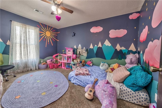 carpeted bedroom with visible vents, a textured ceiling, an accent wall, and ceiling fan