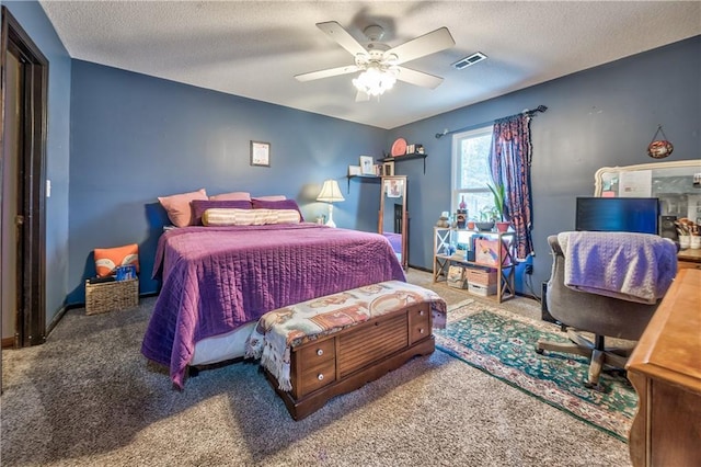 bedroom with visible vents, ceiling fan, a textured ceiling, and carpet