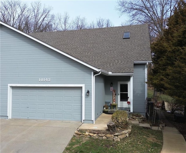 view of front of property with concrete driveway, a garage, and roof with shingles