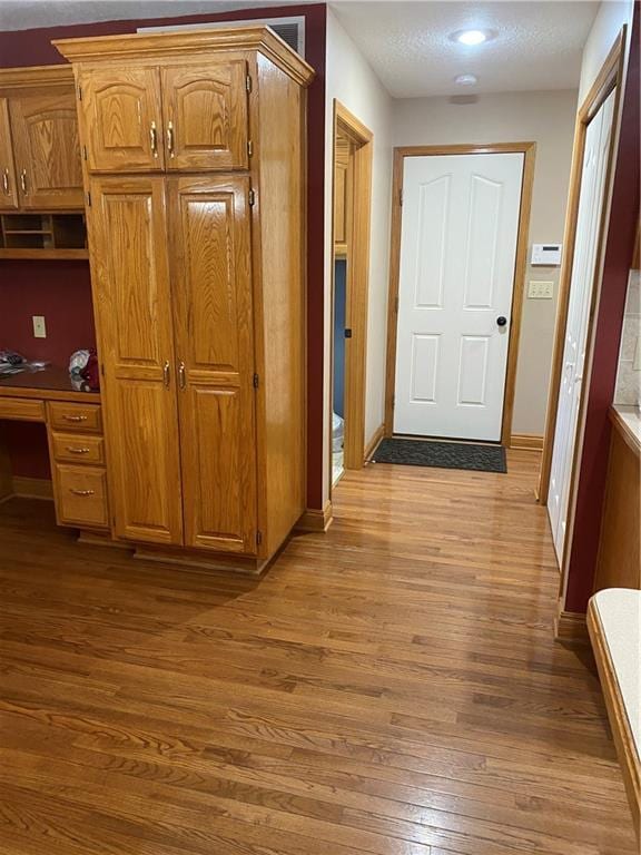 hallway with light wood-type flooring and baseboards