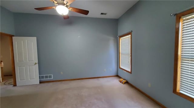 carpeted empty room featuring a ceiling fan, baseboards, and visible vents