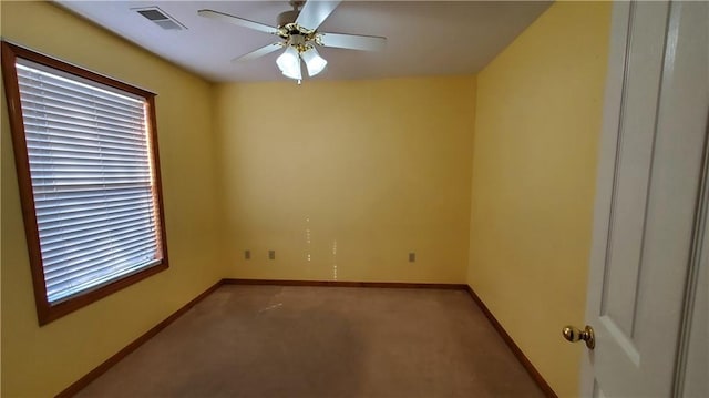 carpeted spare room with a ceiling fan, baseboards, and visible vents