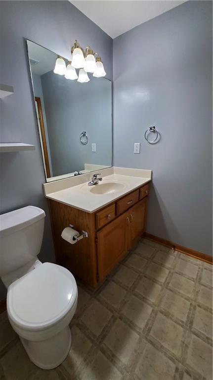 bathroom with tile patterned floors, toilet, vanity, and baseboards