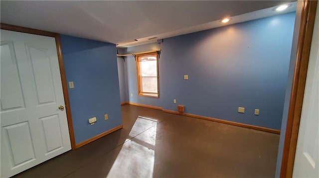 unfurnished room featuring recessed lighting, baseboards, and concrete flooring